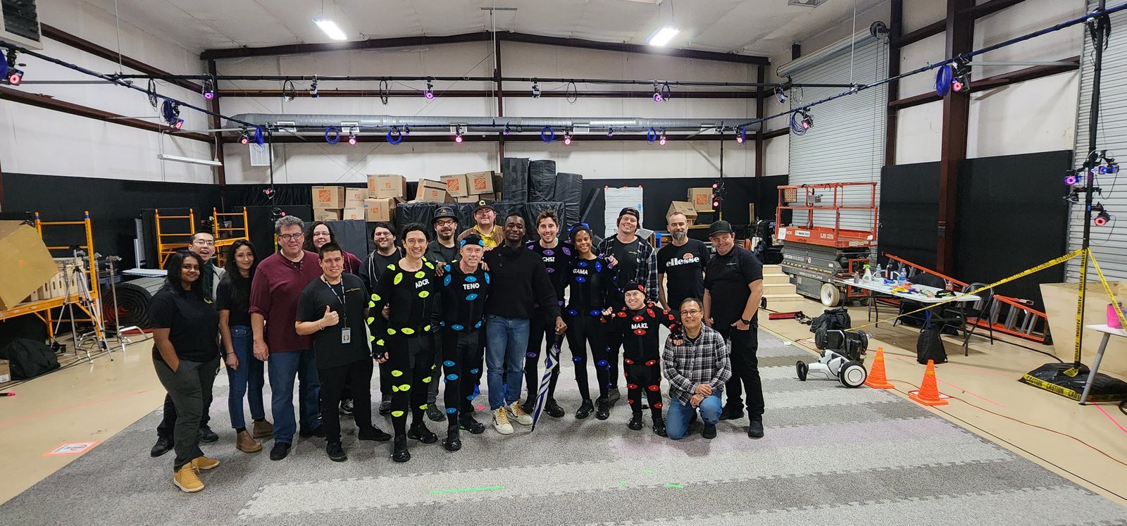 Behind-the-scenes crew and performers inside a large motion-capture volume